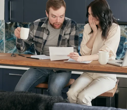 Couple looking over unfair debt collection letter. They Need to contact a local debt collection lawyer.