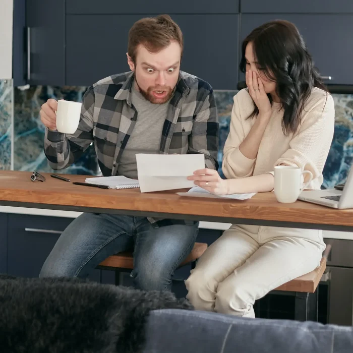 Couple looking over unfair debt collection letter. They Need to contact a local debt collection lawyer.